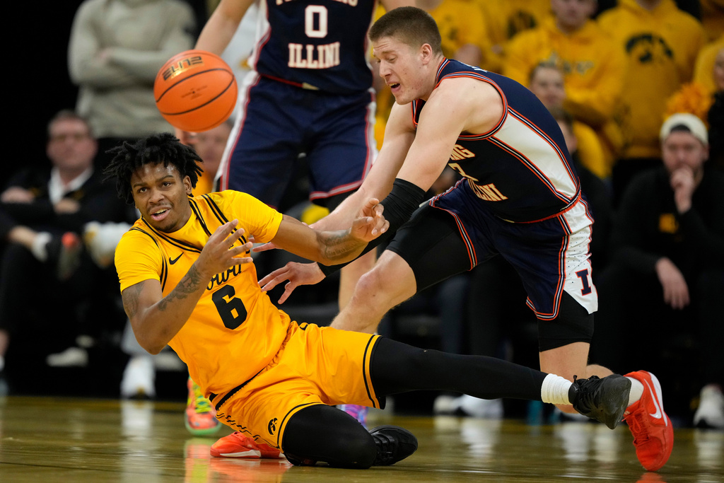 Iowa guard Tavion Banks (6) fights for a loose ball with Illinois forward Ben Humrichous during the first half of an NCAA college basketball game, Sunday, Jan. 11, 2026, in Iowa City, Iowa. (AP Photo/Charlie Neibergall)
