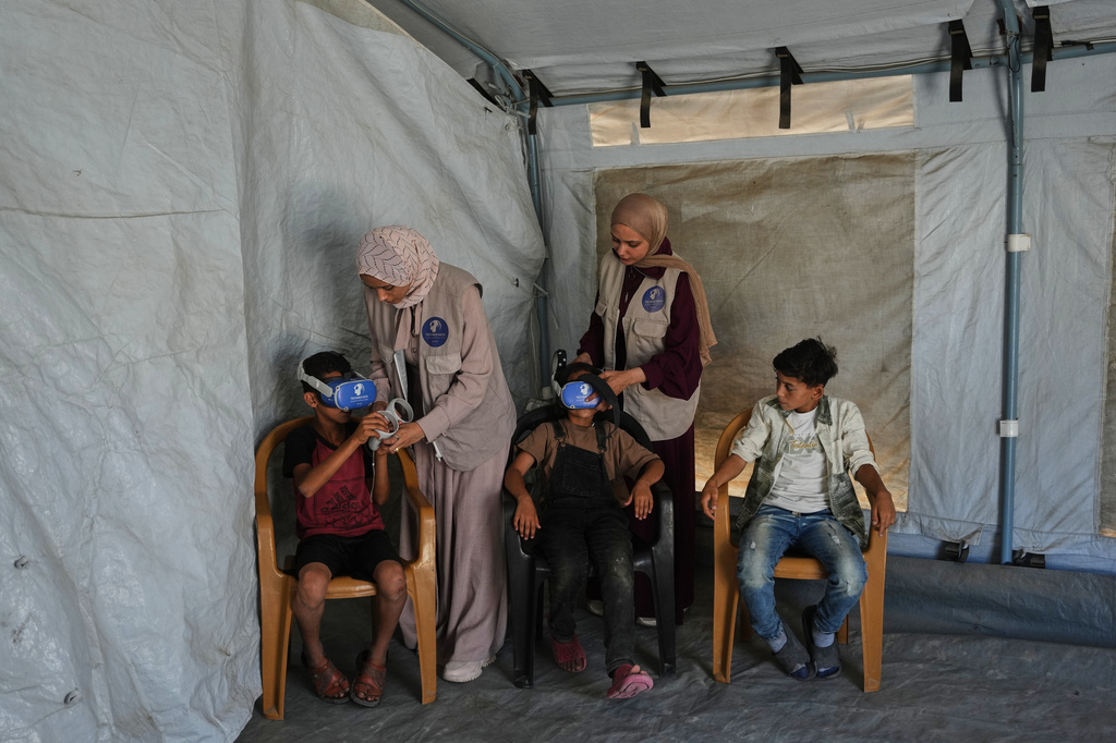 Palestinian children participate in a psychological support session using a virtual reality headset in a tent operated by a medical technology team in Zawaida, central Gaza Strip, Wednesday, June 17, 2026. (AP Photo/Abdel Kareem Hana)