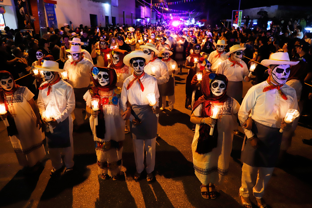 People with skull make up march during the Paseo de las Animas parade as part of the Day of the Dead celebrations in Merida, Mexico, Friday, Oct. 31, 2025. (AP Photo/Martin Zetina)