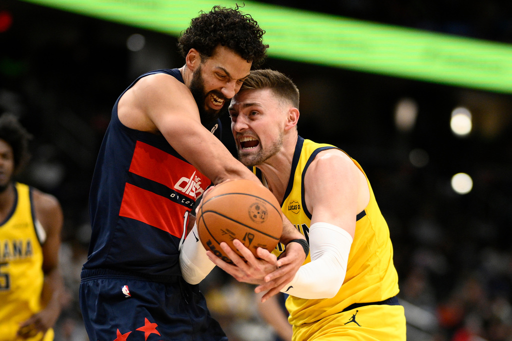 Indiana Pacers center Micah Potter, right, and Washington Wizards forward Anthony Gill, left, battle for the ball during the first half of an NBA basketball game, Friday, Feb. 20, 2026, in Washington. (AP Photo/Nick Wass)