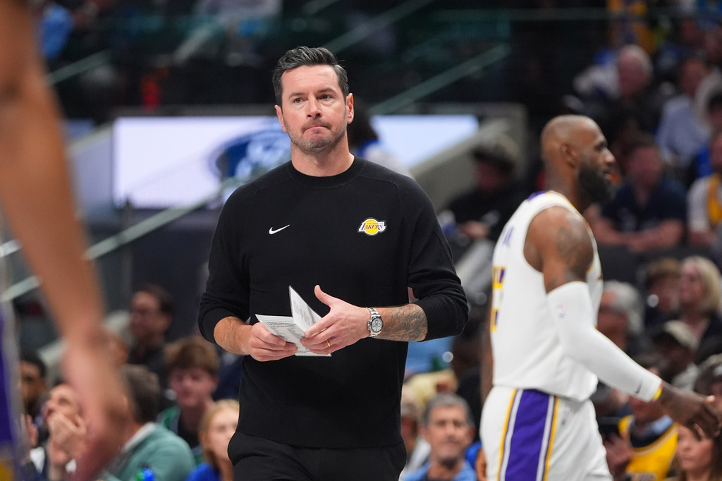 Los Angeles Lakers head coach JJ Redick walks onto the court during a time out in the first half of an NBA basketball game against the Dallas Mavericks in Dallas, Sunday, April 5, 2026. (AP Photo/LM Otero)