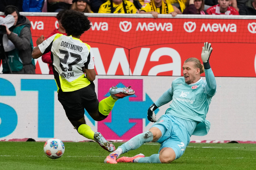 Mainz goalkeeper Robin Zentner, right, makes a tackle on Dortmund's Julian Brandt, during a German Bundesliga soccer match between FSV Mainz 05 and Borussia Dortmund in Mainz, Germany, Saturday, Sept. 27, 2025. (AP Photo/Michael Probst)