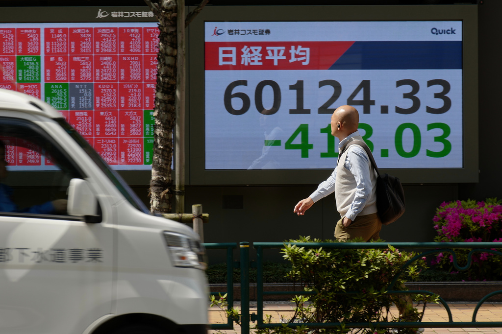 A person walks in front of an electronic stock board showing Japan's Nikkei index at a securities firm, Tuesday, April 28, 2026, in Tokyo. (AP Photo/Eugene Hoshiko)