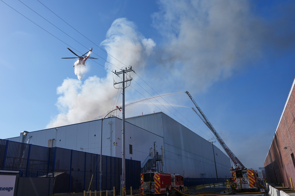 Water is dropped by helicopter at a warehouse fire in the Boyle Heights section of Los Angeles on Wednesday, June 17, 2026. (AP Photo/Jae C. Hong)