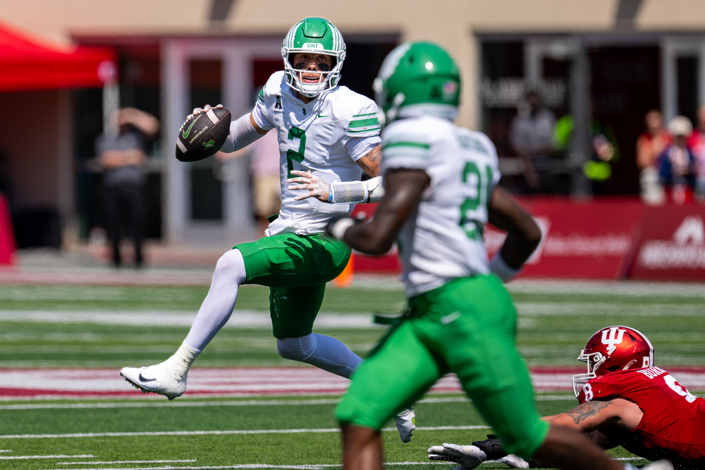 North Texas quarterback Tayven Jackson (2) eludes the grasp of Indiana defensive lineman Josh Burnham (8) as he looks upfield for a receiver during the second half of an NCAA college football game, Saturday, Sept. 5, 2026, in Bloomington, Ind. (AP Photo/Doug McSchooler)