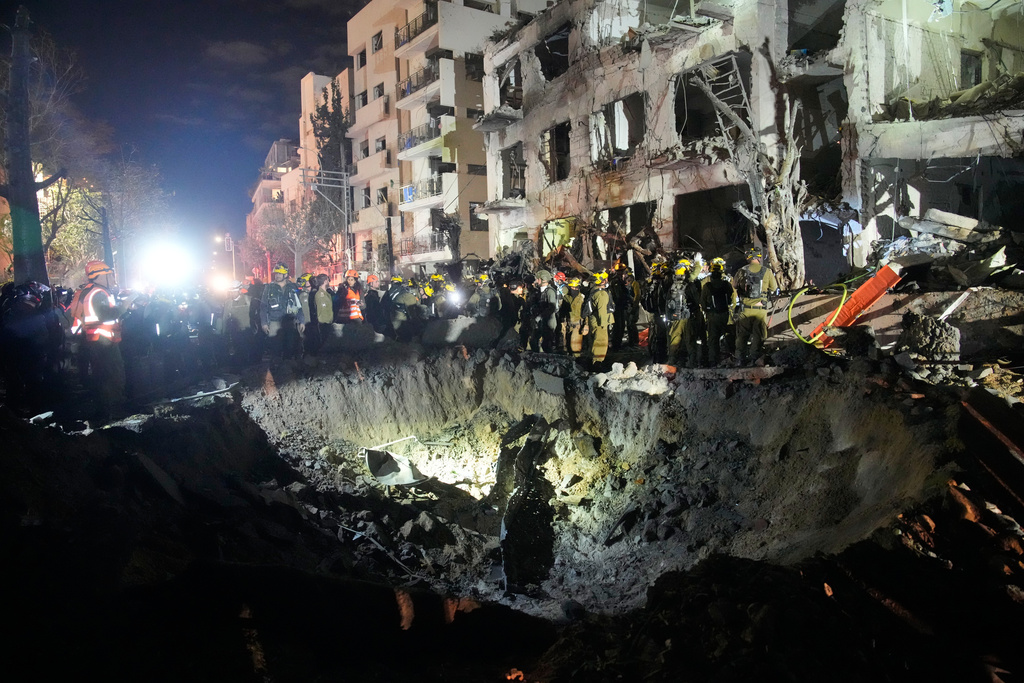 Officers from Israel's Home Front Command search through the rubble of a damaged apartment building after an Iranian missile strike, in Tel Aviv, Israel, early Sunday, March 1, 2026. (AP Photo/Ohad Zwigenberg)