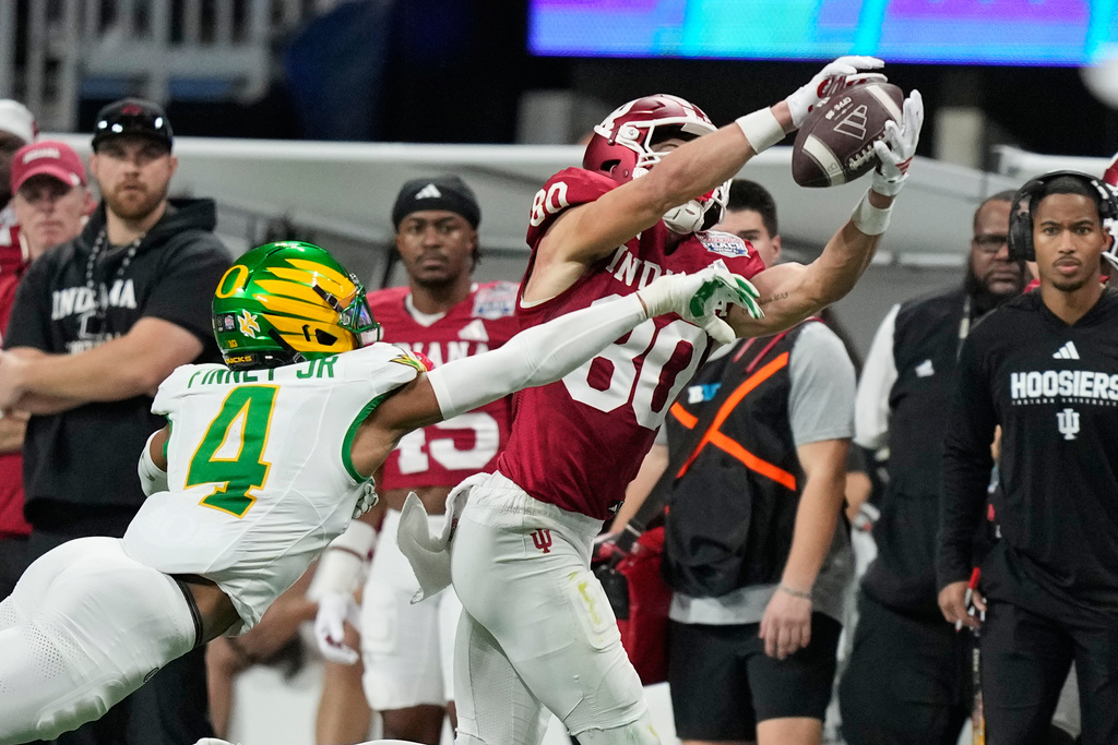 Indiana wide receiver Charlie Becker (80) pulls in a pass against Oregon defensive back Brandon Finney (4) during the second half of the Peach Bowl NCAA college football playoff semifinal, Friday, Jan. 9, 2026, in Atlanta. (AP Photo/Brynn Anderson)