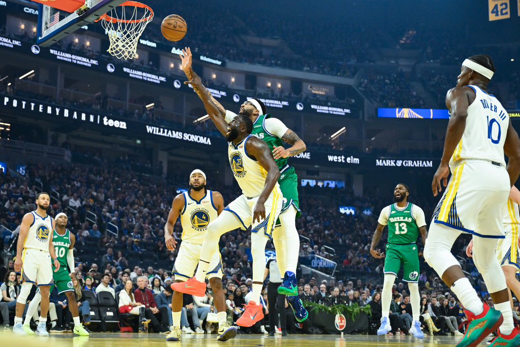 Golden State Warriors forward Draymond Green and Dallas Mavericks forward Anthony Davis reach for a rebound during the first half of an NBA basketball game, Thursday, Dec. 25, 2025, in San Francisco. (AP Photo/Eakin Howard)