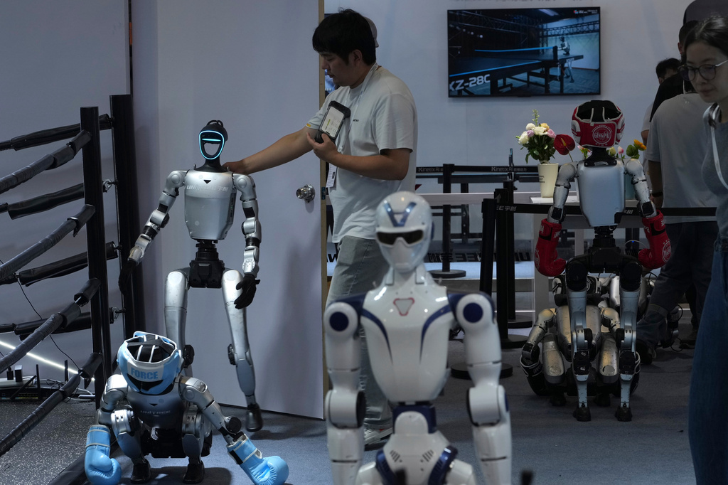 A worker gets a robot ready for demonstration at a booth for leading Chinese commercial humanoid robotics firm Unitree Robotics during the World AI Conference in Shanghai, China, on July 18, 2026. (AP Photo/Ng Han Guan)