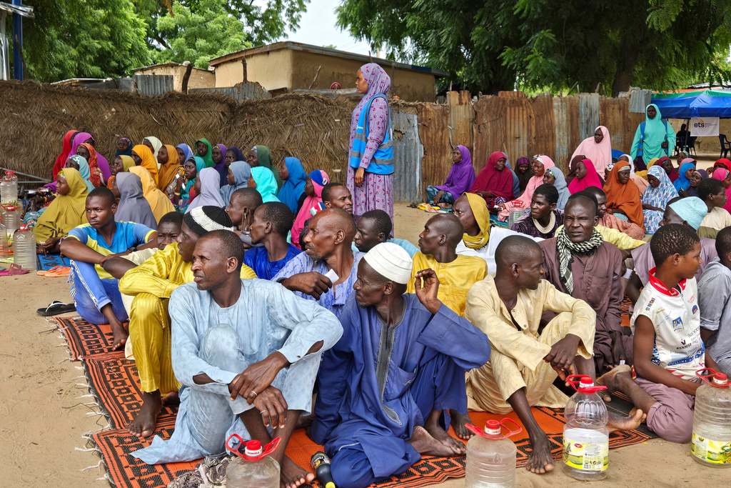 FILE - People wait to receive food donations from the United Nations World Food Program in Damasak, northeastern Nigeria, Oct. 6, 2024. (AP Photo/Chinedu Asadu, File)