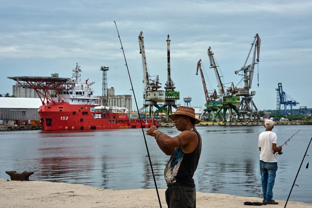 A fisherman prepares his fishing rod in front of the Colombian Navy ship ARC Caribe, docked at a pier in Havana, Cuba, after arriving with humanitarian aid, Friday, June 12, 2926. (AP Photo/Ramon Espinosa)