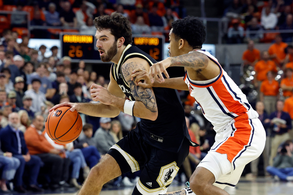 Wofford guard Cayden Vasko (0) dribbles around Auburn guard Kaden Magwood (5) during the first half of an NCAA college basketball game, Tuesday, Nov. 11, 2025, in Auburn, Ala. (AP Photo/Butch Dill)