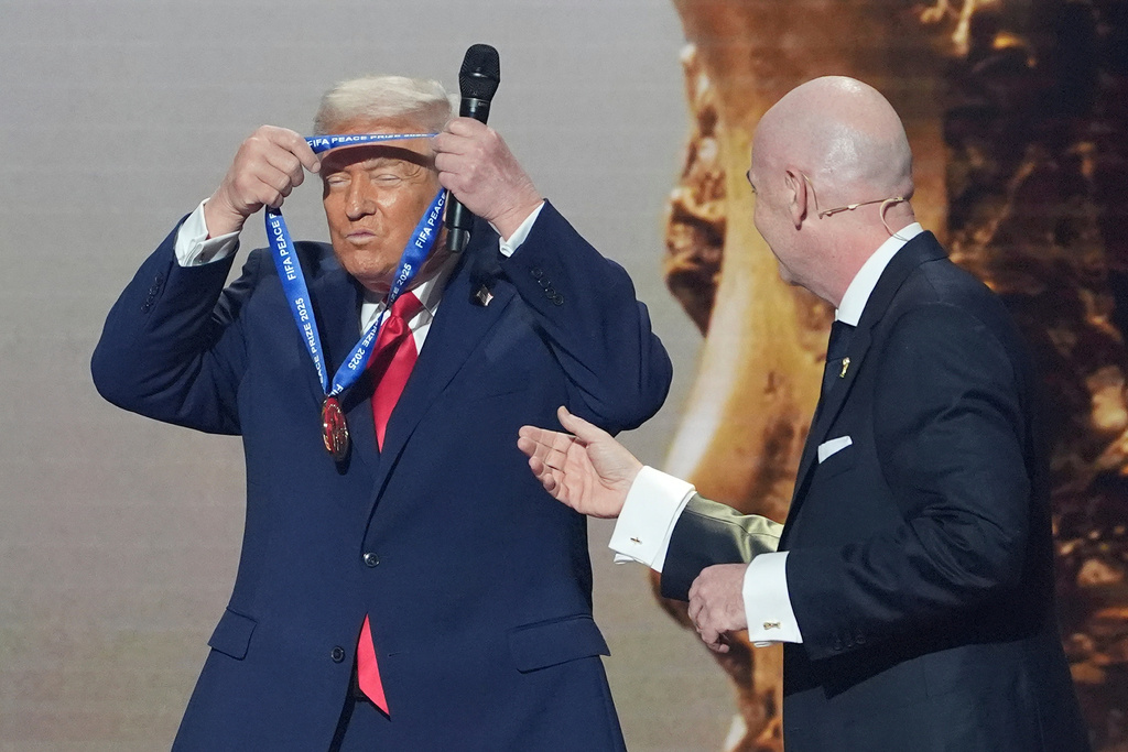 President Donald Trump is presented with the inaugural FIFA Peace Prize by FIFA President Gianni Infantino during the 2026 FIFA World Cup draw at the Kennedy Center, Friday, Dec. 5, 2025, in Washington. (AP Photo/Evan Vucci)