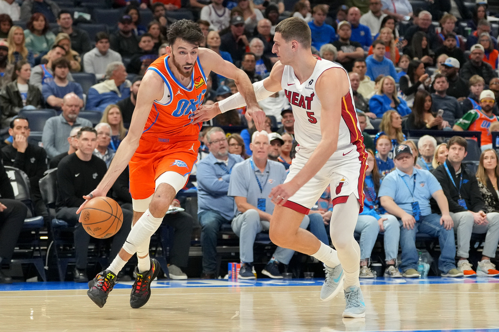 Oklahoma City Thunder center Chet Holmgren, left, drives past Miami Heat forward Nikola Jovic, right, during the second half of an NBA basketball game, Sunday, Jan. 11, 2026, in Oklahoma City. (AP Photo/Kyle Phillips)