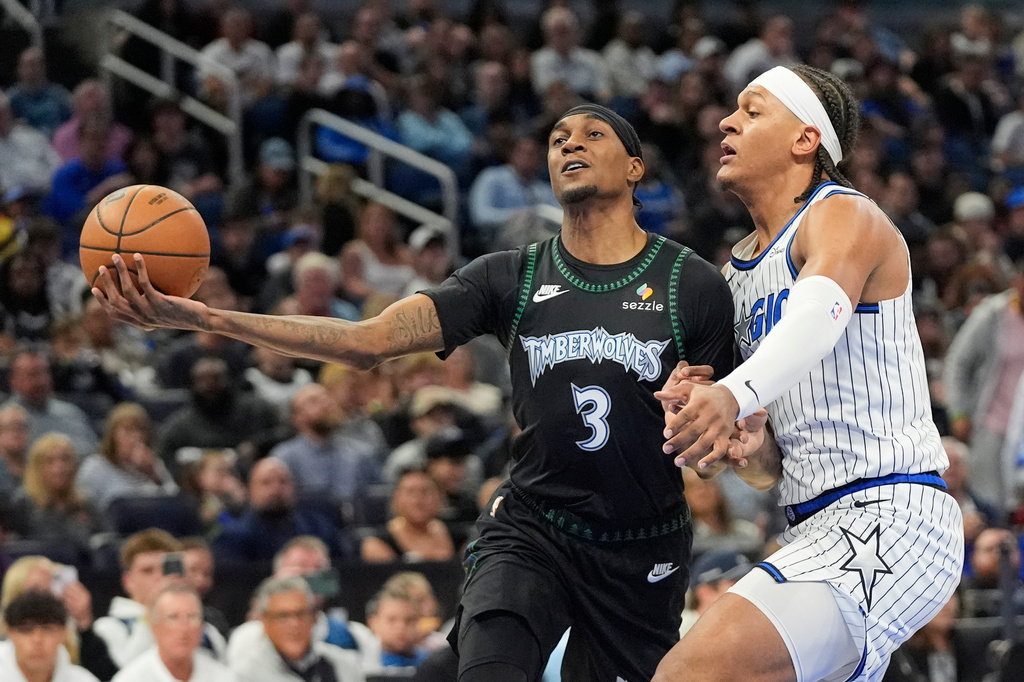 Minnesota Timberwolves forward Jaden McDaniels (3) goes up for a shot against Orlando Magic forward Paolo Banchero during the first half of an NBA basketball game, Wednesday, April 8, 2026, in Orlando, Fla. (AP Photo/John Raoux)