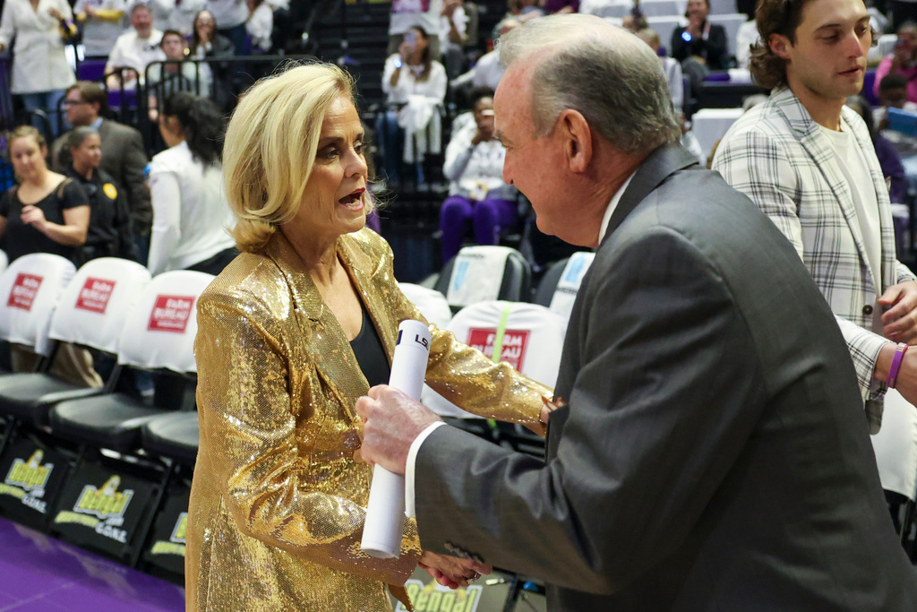 LSU head coach Kim Mulkey, left, greets Texas head coach Vic Schaefer, right, in the first half of an NCAA college basketball game in Baton Rouge, La., Sunday, Jan. 11, 2026. (AP Photo/Peter Forest)
