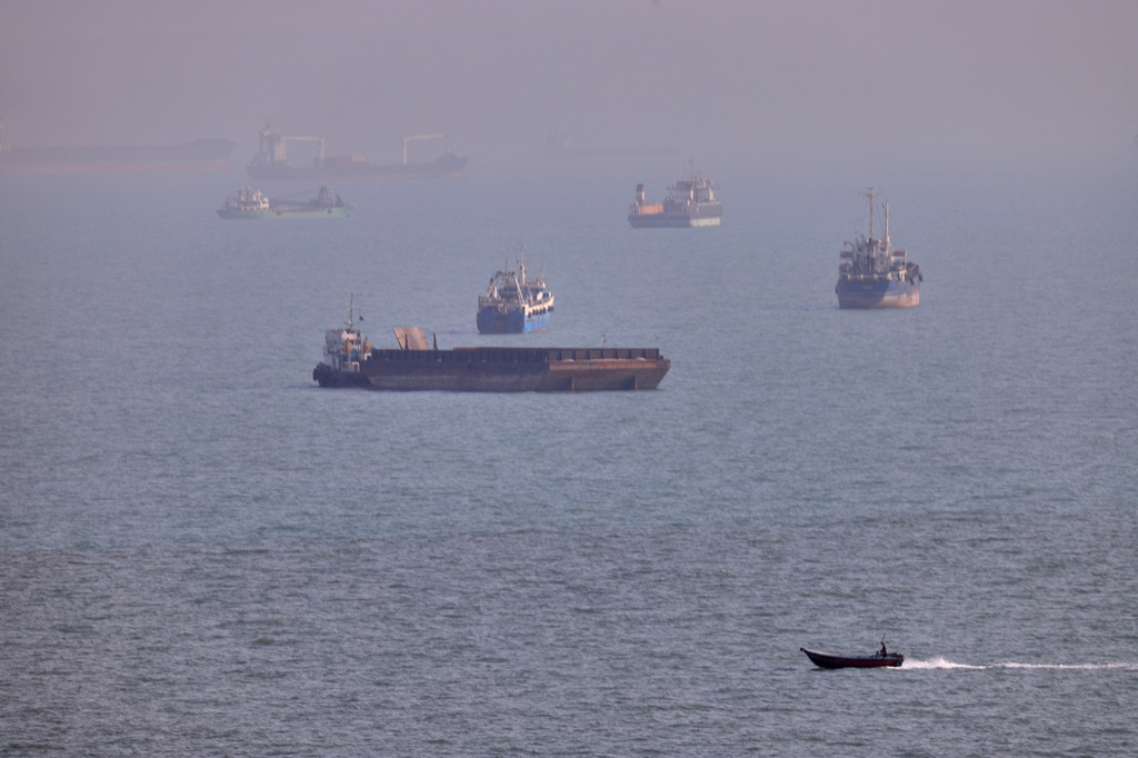 FILE - A small boat sails past cargo ships and other commercial vessels anchored in the Strait of Hormuz off Bandar Abbas, Iran, Wednesday, Aug. 5, 2026. (Amirhosein Khorgooi/ISNA via AP, File)