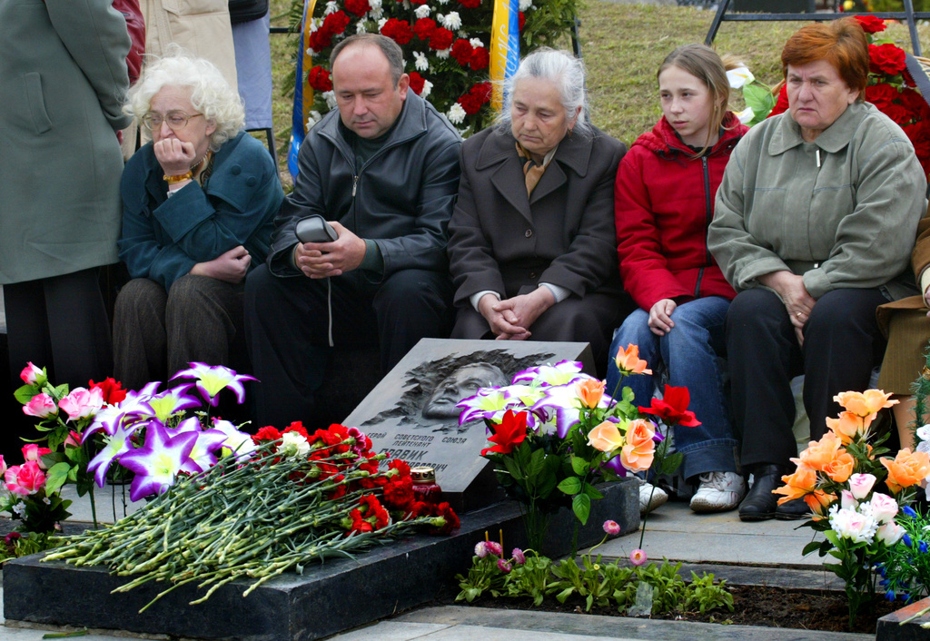 FILE - Relatives of firefighter Vladimir Pravik mourn at his grave at the Mitinskoye Cemetery in Moscow, Russia, on April 26, 2005. Pravik was among the first responders to the explosion and fire at the Chernobyl nuclear plant on April 26, 1986. (AP Photo/ Misha Japaridze, File)