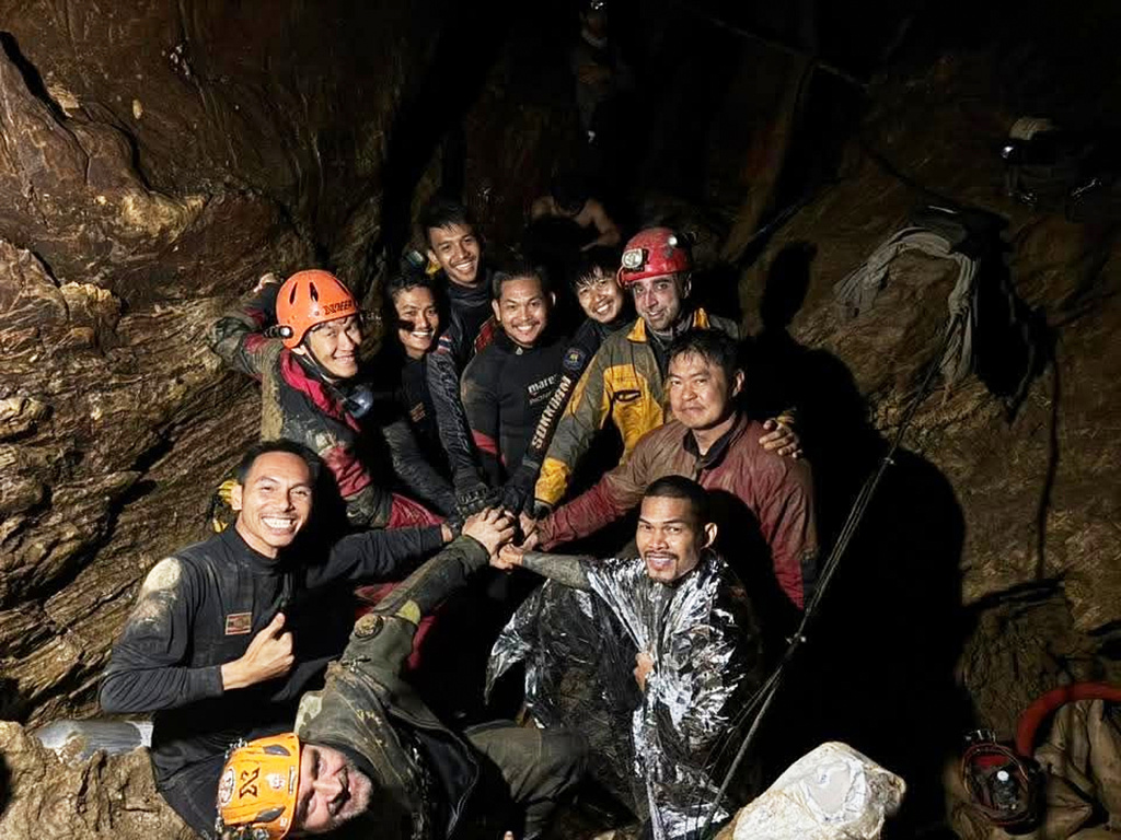 This image released by Metta Tham Rescue Kalasin, shows rescue workers gathering in a flooded cave in Xaisomboun province, Laos, Friday, May 29, 2026. (Metta Tham Rescue Kalasin via AP)