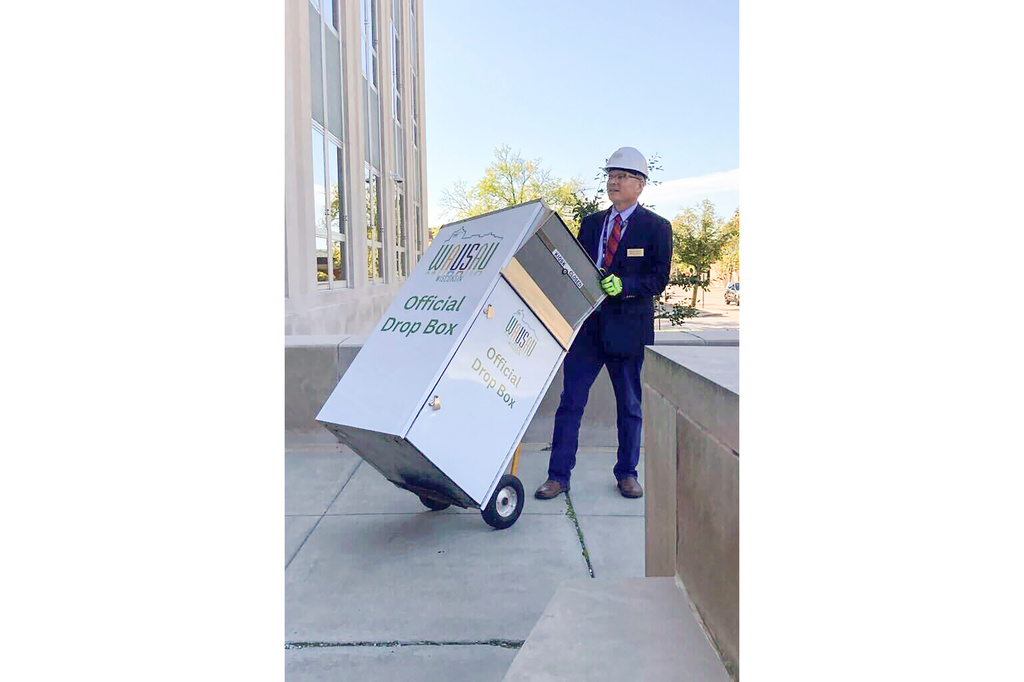 FILE - In this photo provided by Wausau Mayor Doug Diny, Diny uses a dolly to remove the city's lone drop box from in front of City Hall, in Wausau, Wis., on Sept. 22, 2024. (Doug Diny via AP, File)