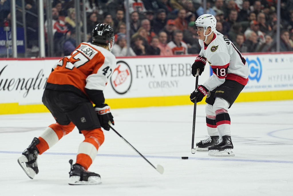 Ottawa Senators' Tim Stützle (18) looks to pass past Philadelphia Flyers' Noah Juulsen during the third period of an NHL hockey game, Thursday, Feb. 5, 2026, in Philadelphia. (AP Photo/Matt Rourke)