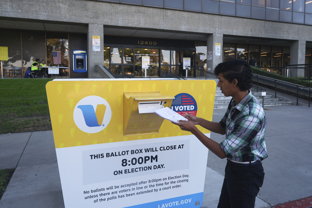 Voter Alex Colcho, from Norwalk, Calif., drops off his family's ballots at a ballot box at the Los Angeles County Registrar-Recorder's headquarters Wednesday, Oct. 29, 2025, in Norwalk, Calif. (AP Photo/Damian Dovarganes)