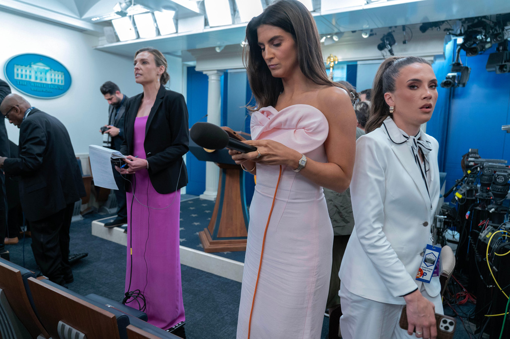 Reporters dressed in evening gowns gala wait for President Donal Trump to speak in the James Brady Press Briefing Room at the White House after a shooting incident outside the ballroom at at the annual White House Correspondents' Association dinner in Washington, Saturday, April 25, 2026. (AP Photo/Jose Luis Magana)