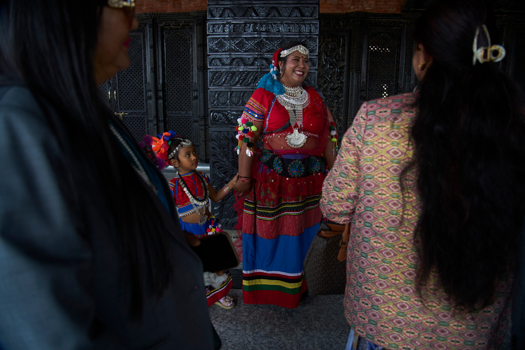 A newly elected member of the House of Representatives in traditional attire arrives with her daughter for a swearing-in ceremony at the Federal Parliament in Kathmandu, Nepal, Thursday, March 26, 2026. (AP Photo/Niranjan Shrestha)