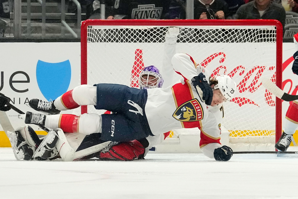 Florida Panthers center Cole Schwindt right, trips over goaltender Sergei Bobrovsky during the first period of an NHL hockey game against the Los Angeles Kings, Thursday, Nov. 6, 2025, in Los Angeles. (AP Photo/Mark J. Terrill)