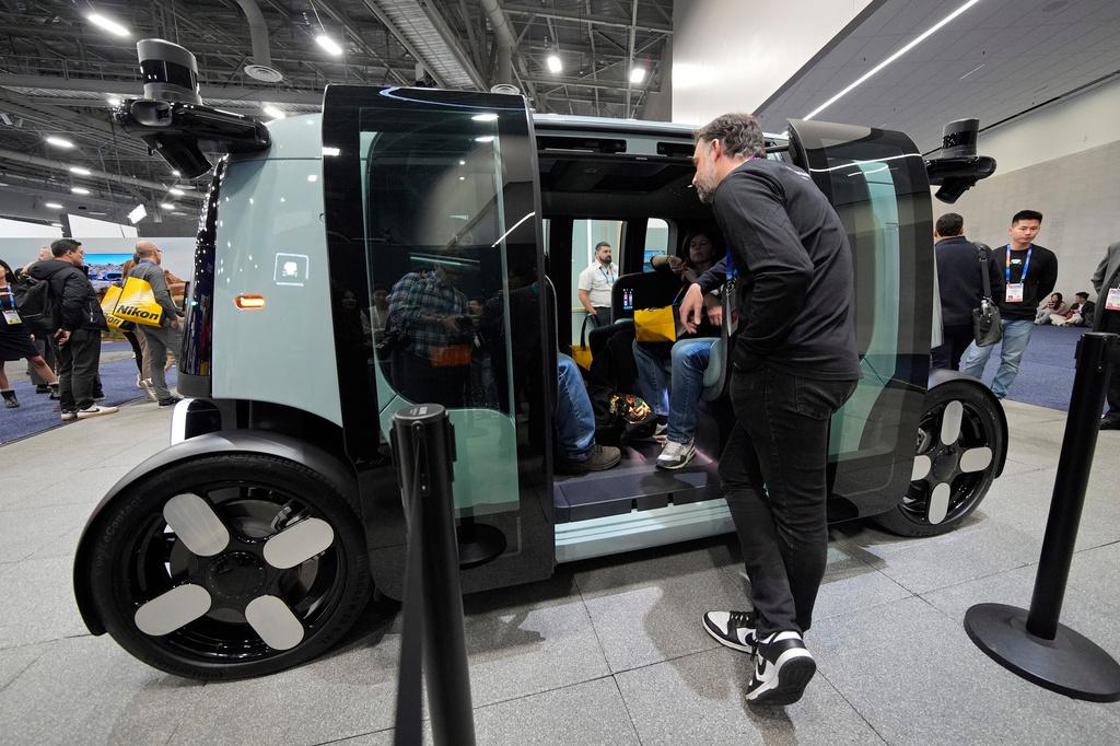 FILE - People view a Zoox self-driving vehicle at the company's booth during the CES tech show, Jan. 7, 2025, in Las Vegas. (AP Photo/John Locher, File)