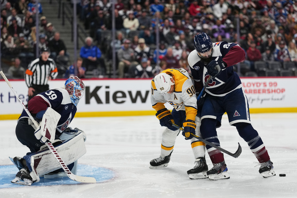 Colorado Avalanche defenseman Brent Burns, right, uses the blade of his skate to block a pass intended for Nashville Predators center Ryan O'Reilly (90) as Avalanche goaltender MacKenzie Blackwood (39) protects the net in the second period of an NHL hockey game Friday, Jan. 16, 2026, in Denver. (AP Photo/David Zalubowski)