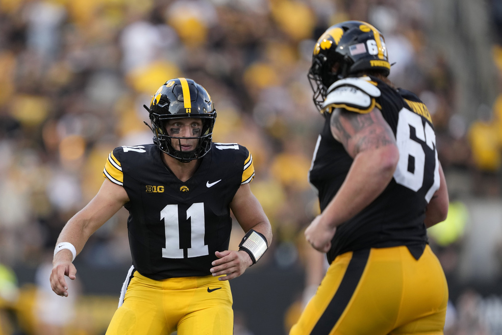 Iowa quarterback Mark Gronowski (11) celebrates with teammate offensive lineman Gennings Dunker (67) after a touchdown during the first half of an NCAA college football game against Albany, Saturday, Aug. 30, 2025, in Iowa City, Iowa. (Photo by Charlie Neibergall)