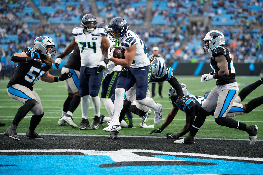 Seattle Seahawks running back Zach Charbonnet scores against the Carolina Panthers during the second half of an NFL football game, Sunday, Dec. 28, 2025, in Charlotte, N.C. (AP Photo/Jacob Kupferman)