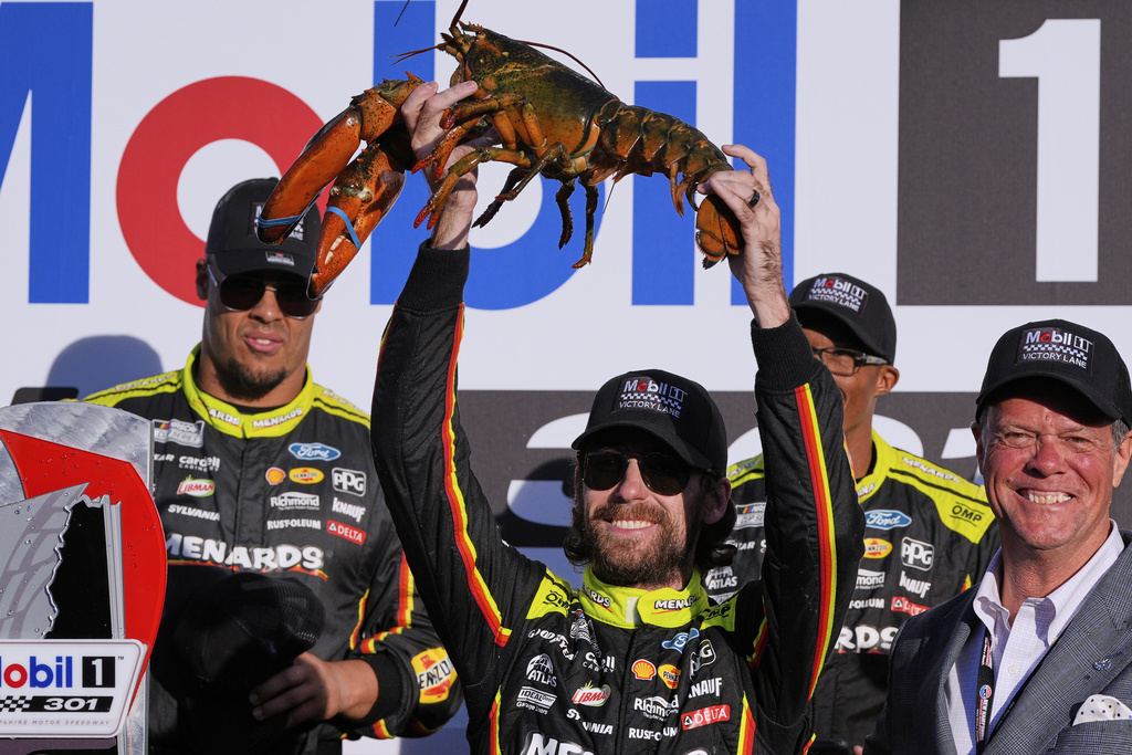 Ryan Blaney hoists a lobster in Victory Lane after winning a NASCAR Cup Series race at New Hampshire Motor Speedway, Sunday, Sept. 21, 2025, in Loudon, N.H. (AP Photo/Charles Krupa)