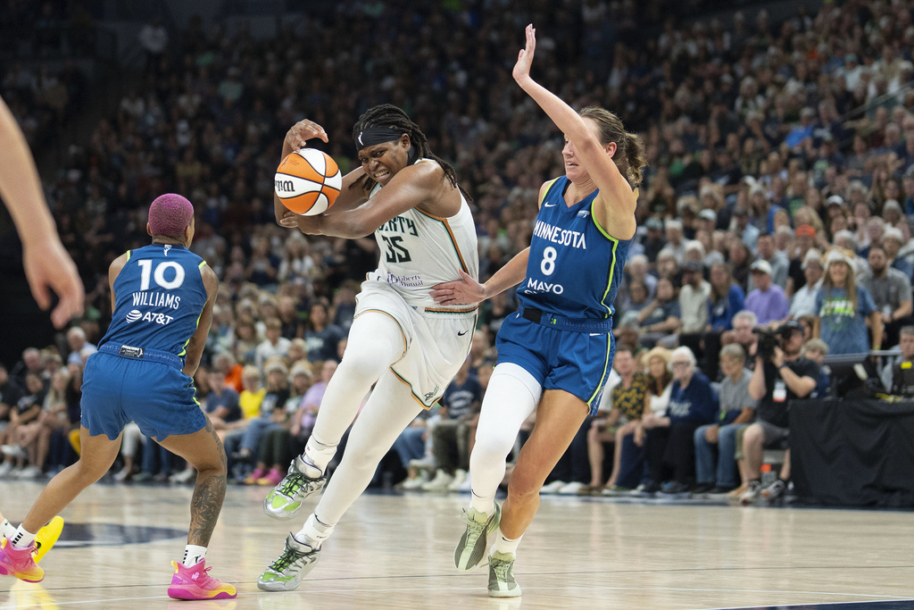 New York Liberty center Jonquel Jones (35) loses control of the ball as she attempts to drive between Minnesota Lynx guard Courtney Williams (10) and Minnesota Lynx forward Alanna Smith (8) in the fourth quarter of a WNBA basketball game Saturday, Aug. 16, 2025, in Minneapolis. (Alex Kormann/Star Tribune via AP)