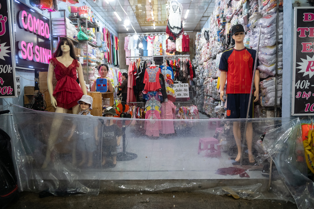 A woman puts up a plastic barrier to keep floodwater out of her shop, as rain and high tide cause flooding on Pham Huu Lau Street in Ho Chi Minh City, Vietnam, Wednesday, Sept. 30, 2026. (AP Photo/Thanh Hue)
