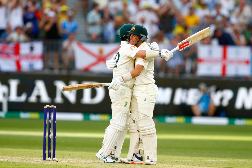 Australia's Travis Head, left, is hugged by batting partner Marnus Labuschagne after the former got out on day two of the first Ashes cricket test match between Australia and England in Perth, Saturday, Nov. 22, 2025.(AP Photo/Gary Day)