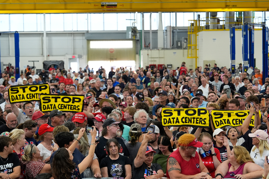 People wait for President Donald Trump to arrive at an event at the General Motors Proving Ground Monday, July 27, 2026, in Milford, Mich. (AP Photo/Paul Sancya)