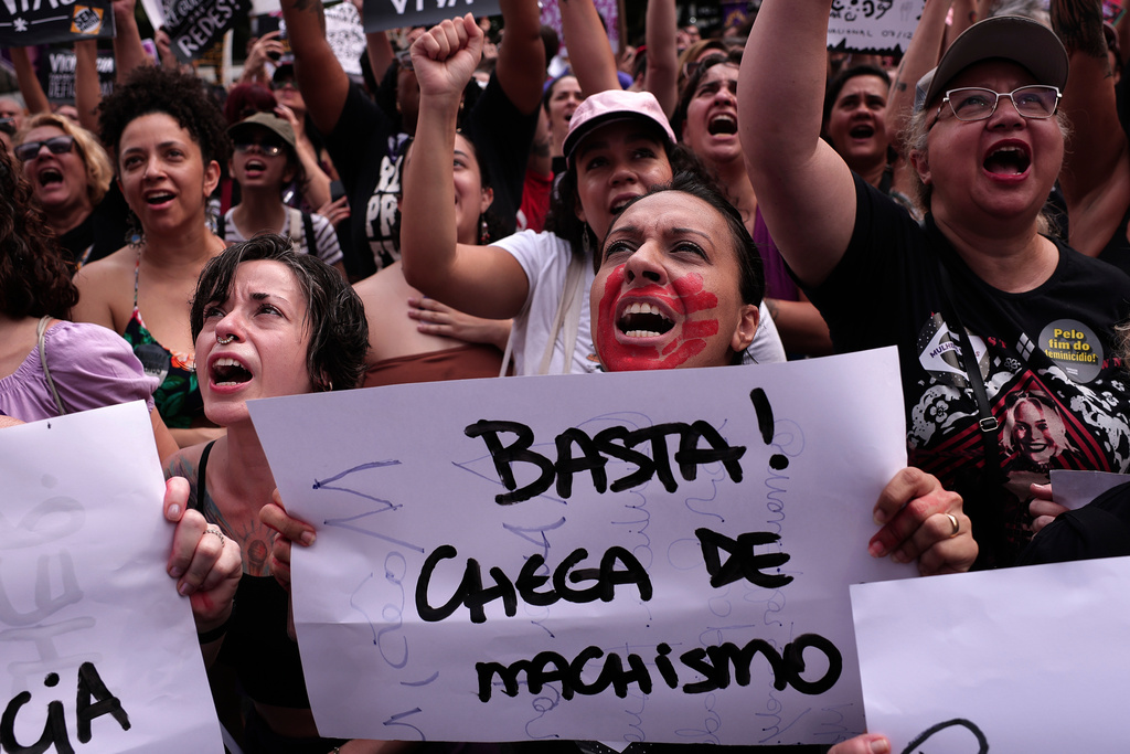 A demonstrator holds up a sign that reads in Portuguese, "Enough! Enough of machismo," during a march against femicide following a series of high-profile cases in the country, in Sao Paulo, Sunday, Dec. 7, 2025. (AP Photo/Ettore Chiereguini)