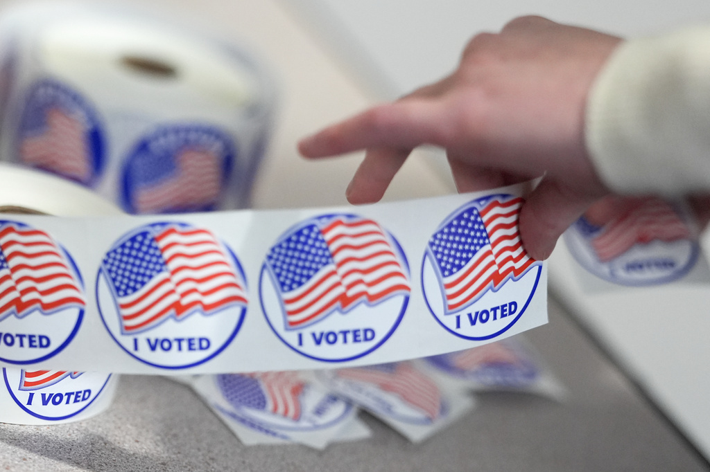 An election worker tears off "I Voted" stickers during the Virginia redistricting referendum at Fairfax Government Center, Tuesday, April 21, 2026, in Fairfax, Va. (AP Photo/Julia Demaree Nikhinson)