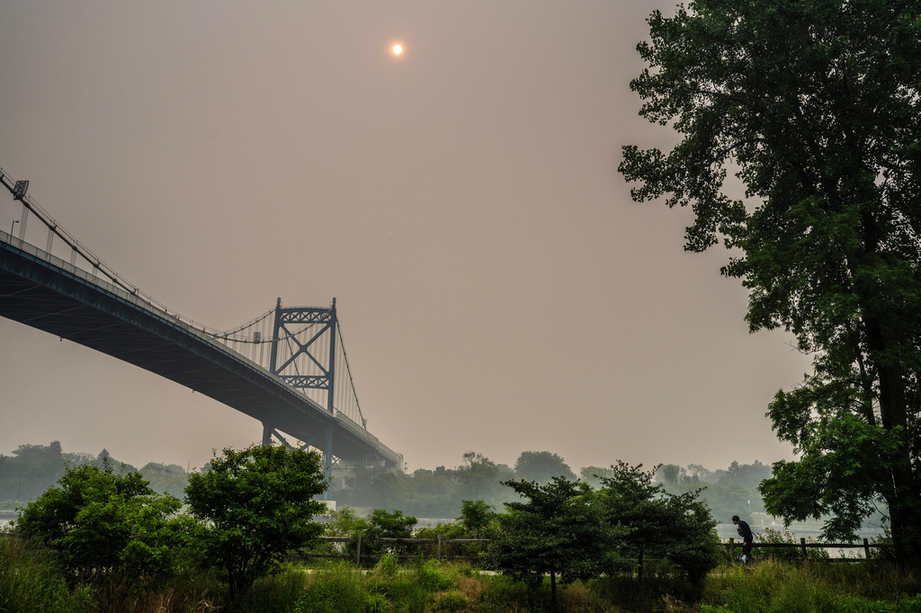 A man rides a Segway as smoke from the Canadian wildfires blankets the sky over Middlegrounds Metropark in Toledo, Ohio, on Thursday, July 16, 2026. (Jeremy Wadsworth/The Blade via AP)