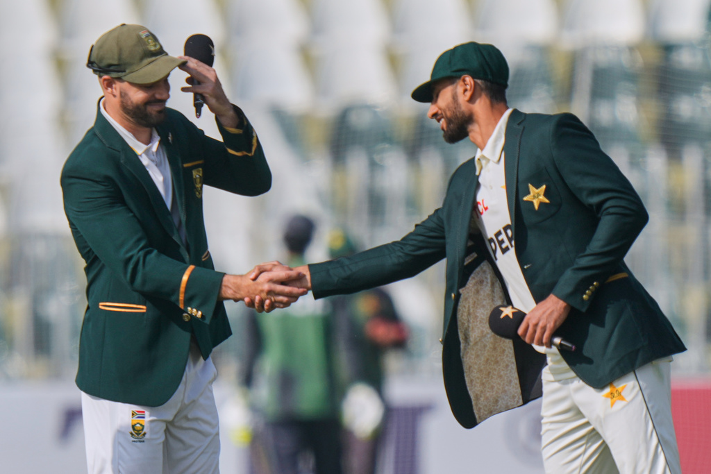 Pakistan's Shan Masood, right, shakes hand with South Africa's Aiden Markram after coin toss before the start of the play of second test cricket match between Pakistan and South Africa, at the Rawalpindi Cricket Stadium, in Rawalpindi, Pakistan, Monday, Oct. 20, 2025. (AP Photo/Anjum Naveed)
