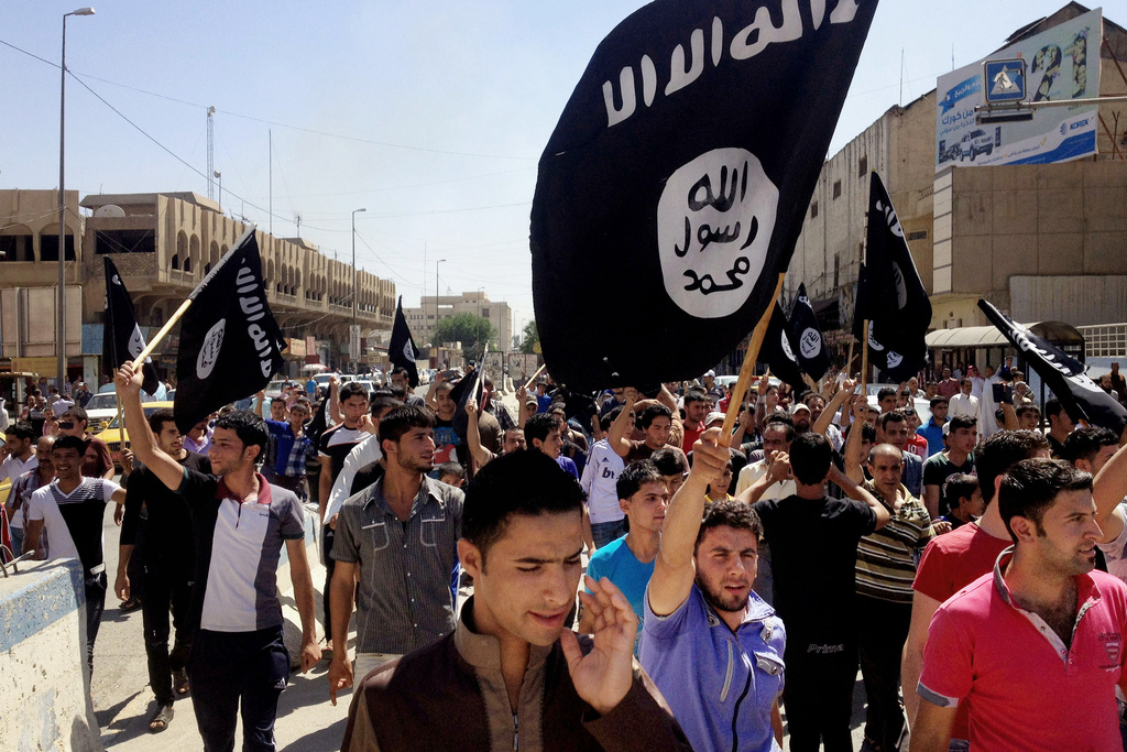 FILE - Demonstrators chant pro-Islamic State slogans as they carry the group's flags in front of the provincial government headquarters in Mosul, 225 miles (360 kilometers) northwest of Baghdad on June 16, 2014. (AP Photo, File)