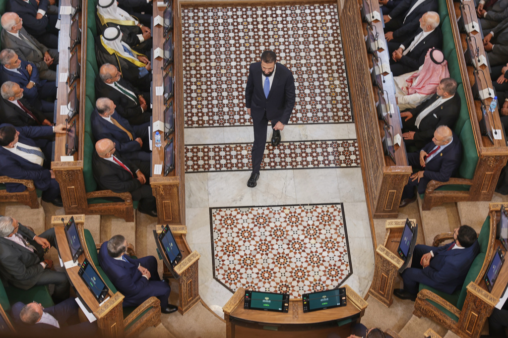 Syrian President Ahmad al-Sharaa walks through the chamber after addressing the inaugural session of Syria's newly formed People's Assembly, the first since the fall of President Bashar Assad's government, in Damascus, Syria, Sunday, July 12, 2026. (AP Photo/Ghaith Alsayed)