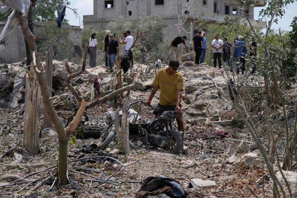 A man removes a damaged scooter from the debris of a destroyed house that was hit in an Israeli airstrike in the village of Burj al-Shamali, southern Lebanon, Thursday, Aug. 6, 2026. (AP Photo/Mohammed Zaatari)