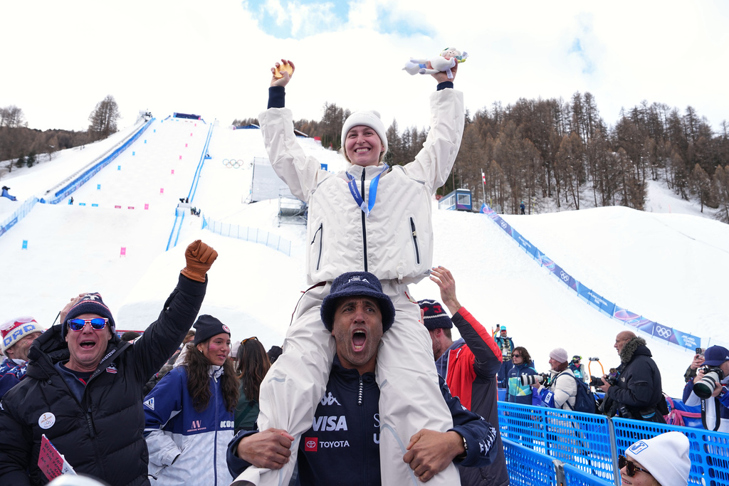 United States' Elizabeth Lemley holds her gold medal while celebrating after winning the women's freestyle skiing moguls finals at the 2026 Winter Olympics, in Livigno, Italy, Wednesday, Feb. 11, 2026. (AP Photo/Gregory Bull)