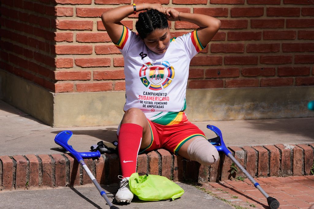 A woman fixes her hair before playing during a women's amputee soccer clinic in Santa Cruz, Bolivia, Friday, July 17, 2026. (AP Photo/Juan Karita)