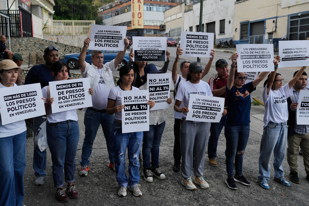 Relatives and friends of political prisoners hold banners calling for their loved ones to be set free outside El Helicoide, the headquarters of Venezuela's intelligence service and detention center, in Caracas, Venezuela, Friday, Jan. 9, 2026 after the government announced prisoners would be released.(AP Photo/Ariana Cubillos)