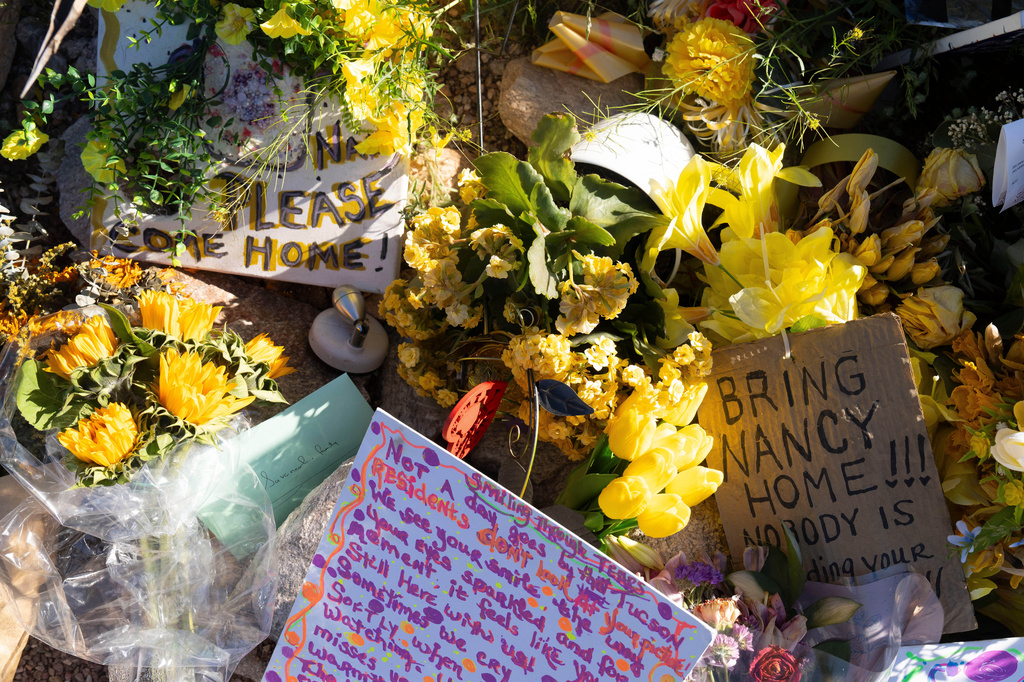 FILE - A collection of yellow flowers and notes sit at the home of Nancy Guthrie, the missing mother of "Today" show host Savannah Guthrie, in Tucson, Ariz., March 6, 2026. (AP Photo/Rebecca Noble, File)