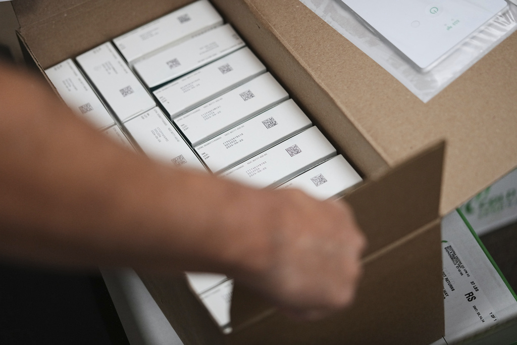 Co-owner Marc Ost at Eric's Rx Shoppe unpacks a shipment of COVID-19 vaccines in Horsham, Pa., Tuesday, Sept. 2, 2025. (AP Photo/Matt Rourke)